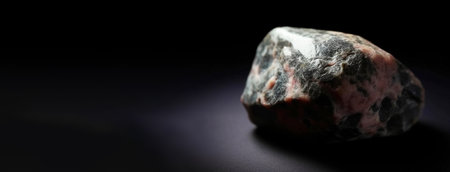 Eveite is a rare precious natural geological stone eremite on a black background in low key. Fashionable jewelry elegant decoration. AI generated. Header banner mockup with space.の素材