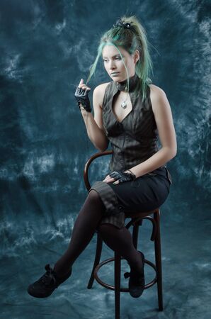 Photo session of the pretty young blonde girl with green hair in the steampunk styleの写真素材