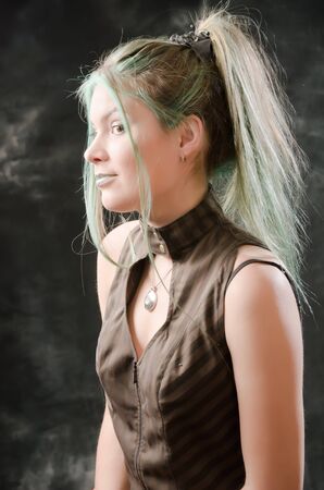 Photo session of the pretty young blonde girl with green hair in the steampunk styleの写真素材