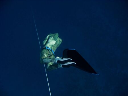 Freediver makes deep dive by line near the coral reef in Blue Hole, Dahab, Egyptの写真素材