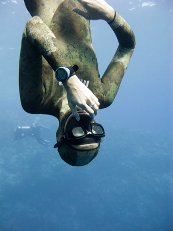 Freediver equalizing pressure while moving down. Meanwhile Blue Hole divers are watching him.の写真素材