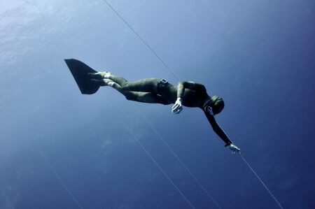 Freediver-woman freezes up in the depth of the Red Sea without any movementの写真素材