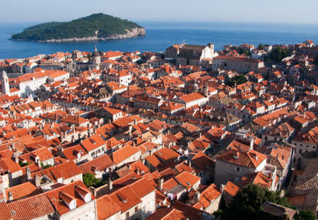 This is a picture ot Dubrovnik red and orange roofs and distant island behind.の写真素材