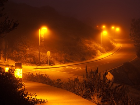 An empty night freeway, illuminated by lamps in a mistの写真素材
