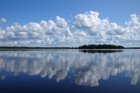 The picture shows typical landscape in the south region of Karelia - blue sky, clouds, big lake looks like a mirror and a lot of distant green islands, trees, stones and rocksの写真素材