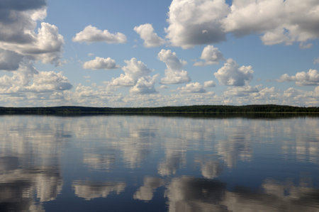 The picture shows typical landscape in the south region of Karelia - blue sky, clouds, big lake...