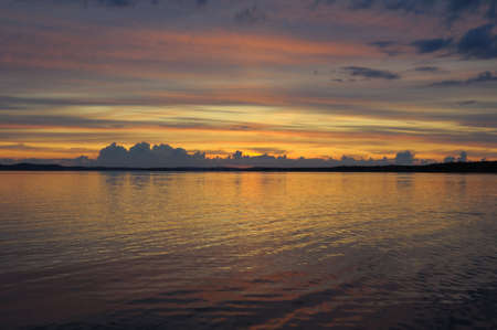 The final stage of a cloudy sunset above the huge lake in Karelia region. The picture is colorful and relaxing.の写真素材