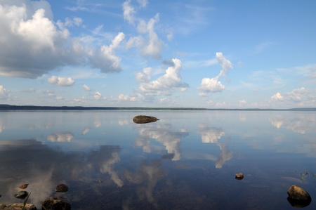 The picture shows typical landscape in the south region of Karelia - blue sky, clouds, big lake looks like a mirror and a lot of distant green islands, trees, stones and rocksの写真素材