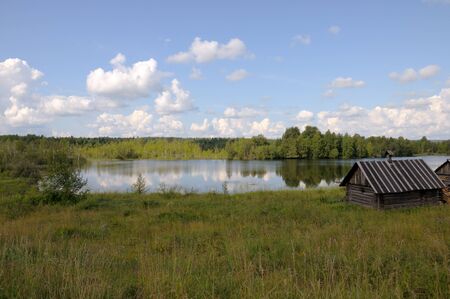 A small bathhouse on a beautiful lake in a forestの写真素材