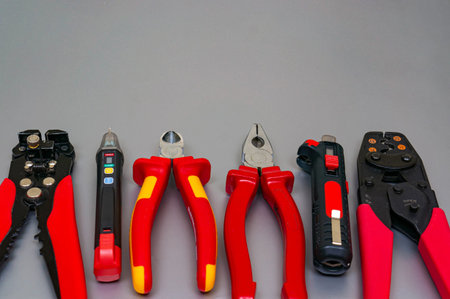 Professional electrician tools on silver background. All tools with red handles. located at the...