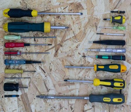 There are many screwdrivers of different sizes opposite each other diagonally on the osb construction plate.の写真素材