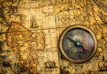Vintage compass on an ancient world map, left.の写真素材