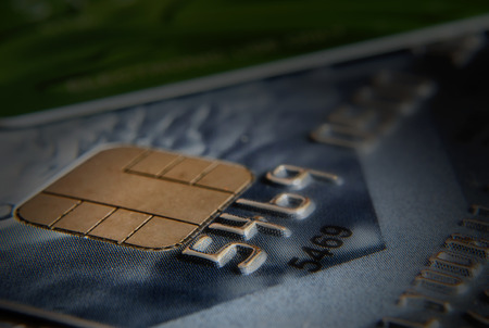 Figures and the chip on a bank card. Close up. Small depth of sharpness. Blackout at the edges. Horizontal format. Indoors. Without people. Color. Photo.の写真素材