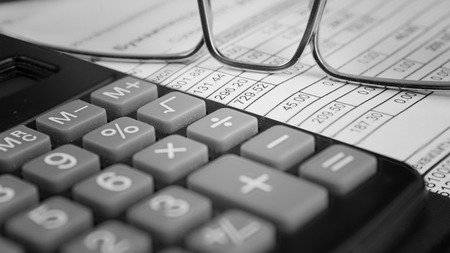 Receipt on payment of utilities and calculator. Close up. Small depth of sharpness. Indoors. The decoloured image. Vignette.の写真素材