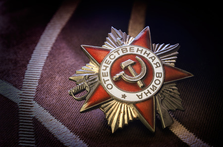 Against a dark background Soviet award Patriotic war of the first degree.Date: 18.04.2018 years. Editorial image.Close up. Indoors. Vignette. Horizontal format. Color. Photo.のeditorial素材