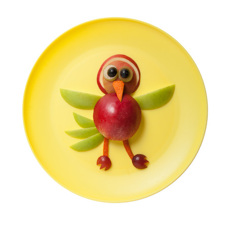 Funny bird made of apple on yellow plateの写真素材