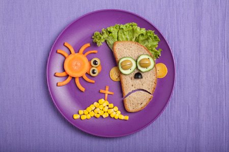 Halloween zombie and spider made of bread vegetables on plate and fabricの写真素材