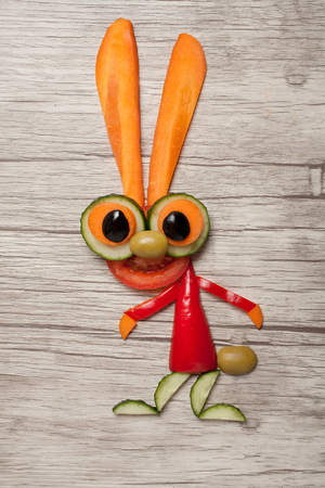 Hare made of green vegetables on tableの写真素材