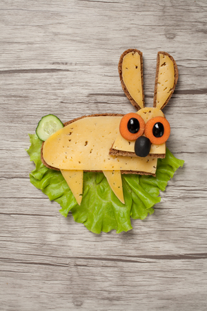 Rabbit made of bread, cheese and vegetables on boardの写真素材