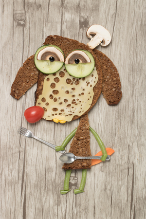 Dog made with bread and vegetables as chef with fork and spoonの写真素材