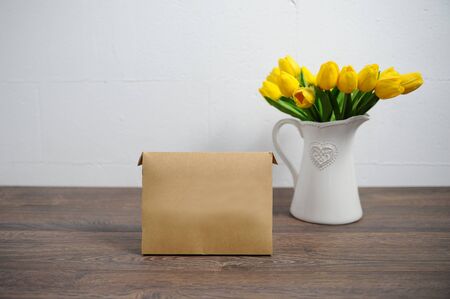 Yellow tulips and boxes on a wooden table.の写真素材
