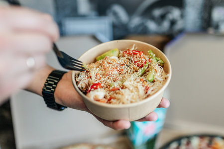 Bowl of rice with vegetables in a woman's hands. Selective focus.