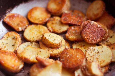 Golden fried potatoes with seasonings on a frying panの写真素材