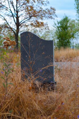 Lonely tombstone granite slab near the roadの写真素材