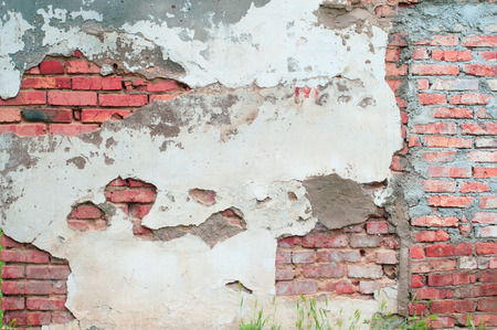 Background of old red shabby cement-cracked bricks with cracksの写真素材
