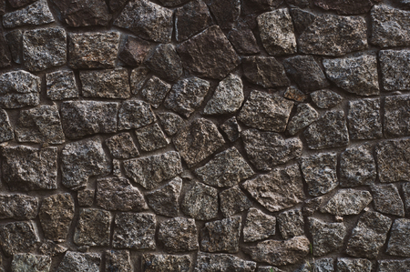 background from a wall erected from roughly treated gray granite stonesの写真素材