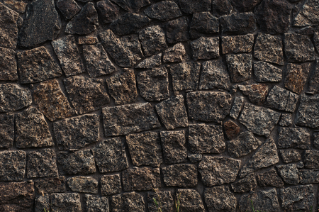 background from a wall erected from roughly treated gray granite stonesの写真素材