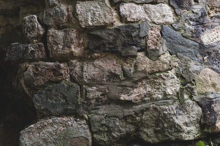 background from the Old darkened wall with granite gray roughly processed rectangular stones close-upの写真素材