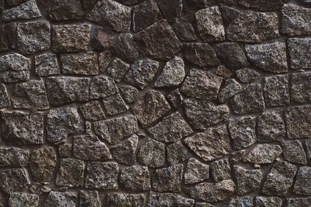 background from a wall erected from roughly treated gray granite stonesの写真素材