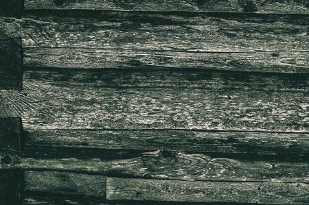 A wall made of old, dark, worn gray ashlar logs.の写真素材