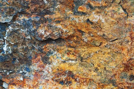 Yellow-red-brown black background from iridescent sandstone close-upの写真素材