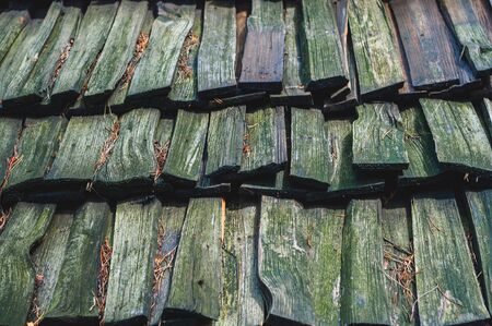 background from old with green moss pine rectangular boards serving to cover the roofの写真素材