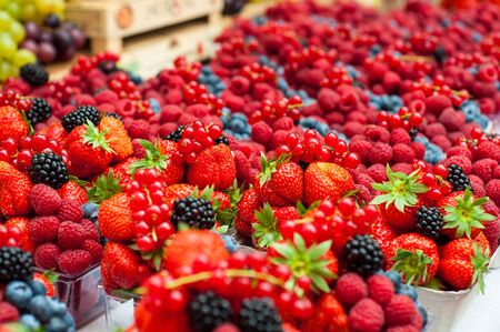 Sale juicy, fresh strawberries, raspberries and blackberries in market square, Prague, Czech Republic. Nutritious healthy berry diet food. Berries close up.の写真素材