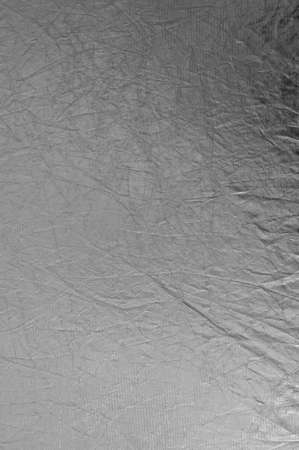Texture silver fabric reflector, simple stretched silver background vertical photo.の写真素材
