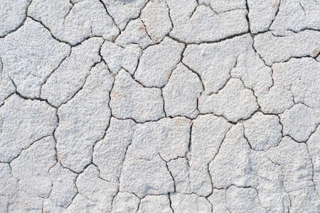 Background cracked, dry white clay, natural material, atmospheric impact, outdoors, horizontal close-up photo. Dry soilの写真素材