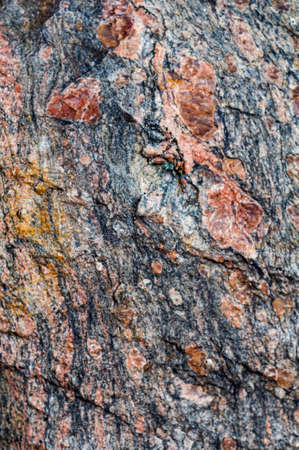 Background with natural rough granite stone, solid colorful texture. Close-up photo. Nature, outdoors. Vertical photo.の写真素材