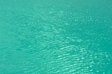 Bright, colorful background close up, turquoise green water surface of the lake, outdoors, horizontal photo.の写真素材