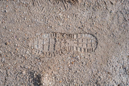 Footprint on clay soil from shoes, natural material, atmospheric influence, outdoors, horizontal close-up photo. Dry soilの写真素材