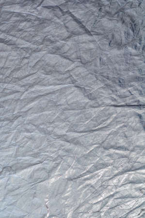 Texture silvery fabric reflector, simple crumpled background, vertical photo.の写真素材