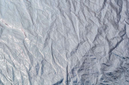 Texture silvery fabric reflector simple, crumpled background, horizontal photo.の写真素材