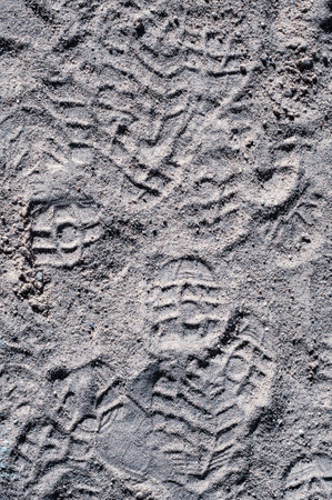 Sand on beach, many footprints in sand, textured surface, vertical photography, natural material, outdoors close-upの写真素材
