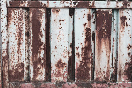 Grunge background cracked shabby white paint rusty metal. Damaged corrugated metal sheet, weathered rusty steel, textured surface. outdoors, vertical close-up photo, blank template for banner design.の写真素材