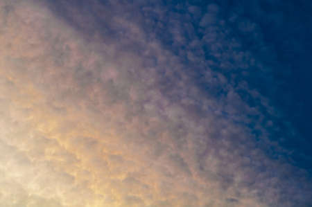 Bright colorful reflection warm sunlight, sunset illuminates dark cloudy sky. Outdoors. Horizontal photographyの写真素材
