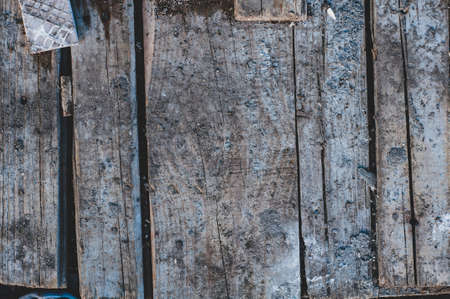 Dirty very old cracked wood plank, vintage wood background with knocked down planks close-up, rough surface, weathering.の写真素材