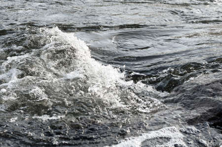 Background, top view, rapid flow river with dark blue water and white foam waves.の写真素材