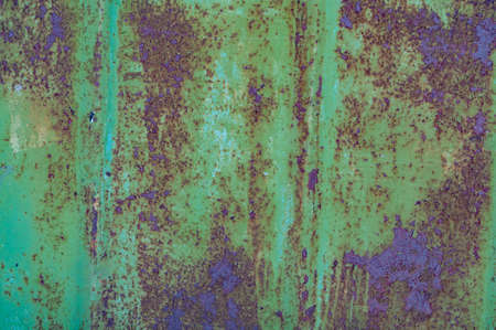 Old background with wooden boards with cracked, peeled red paint, vintage texture, rough textured surface close-up. Exposure to atmosphere, outdoors.の写真素材